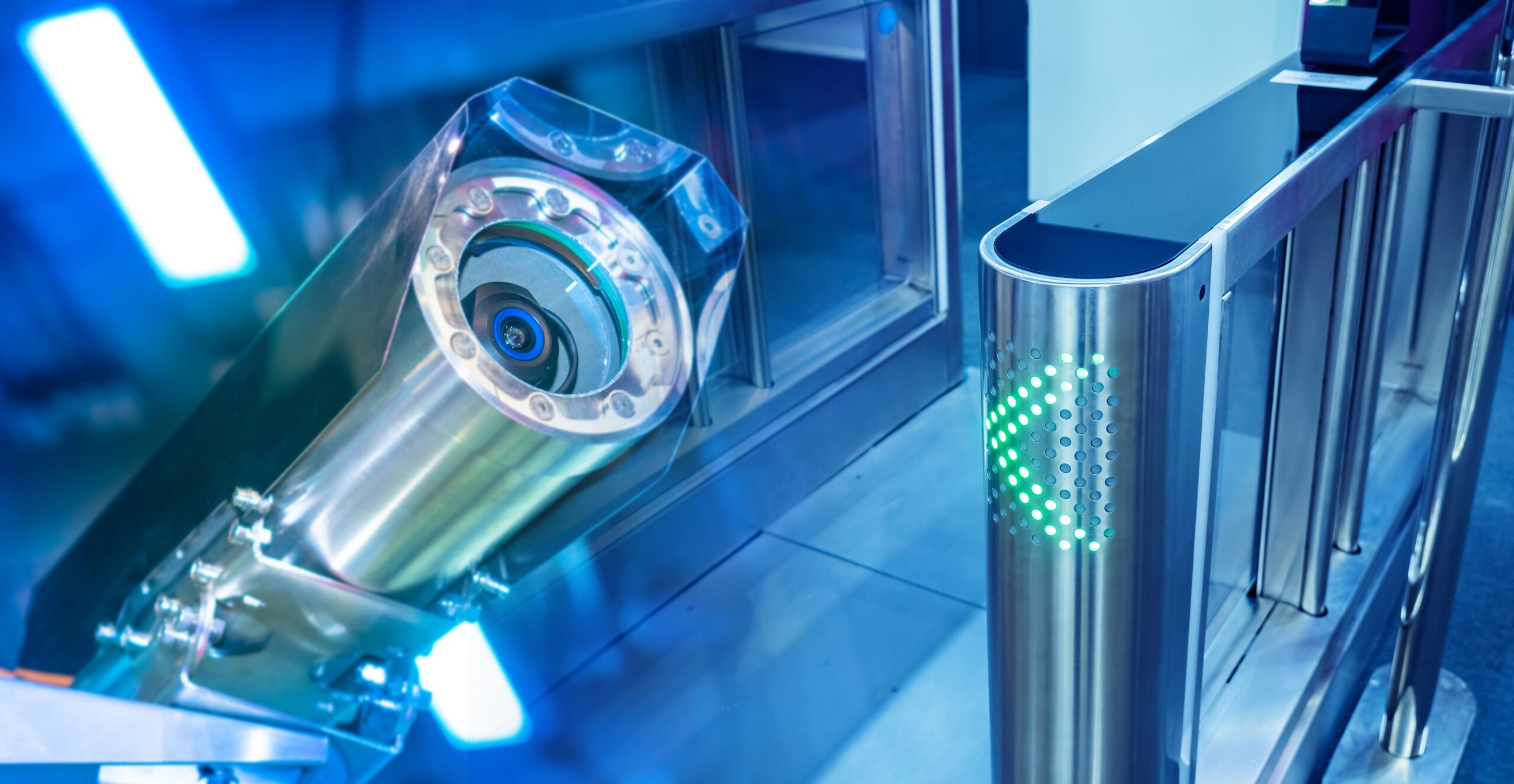 Surveillance camera and access control turnstile with green light indicator.
