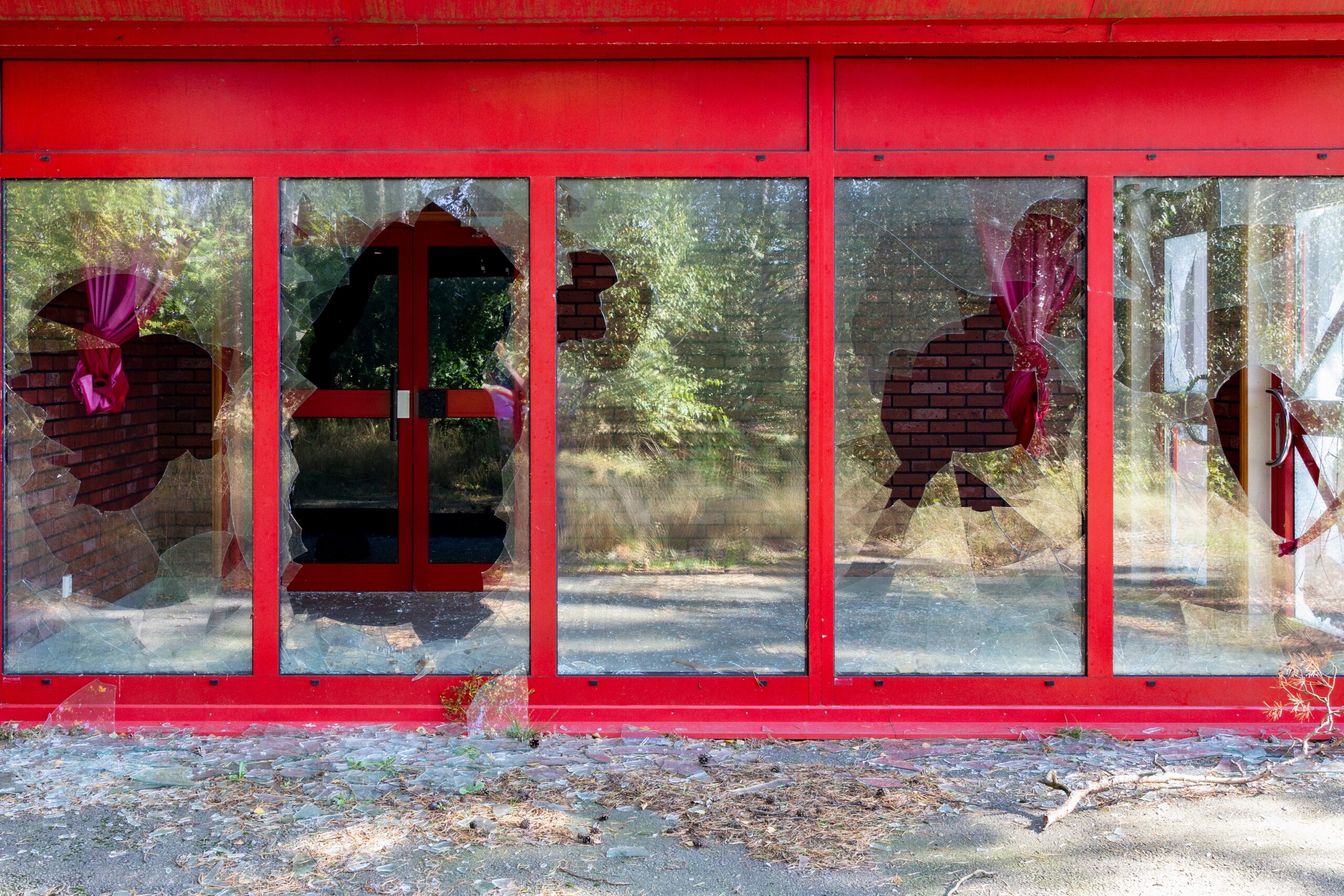 Broken glass on a vacant commercial office building highlighting security risks and property damage.